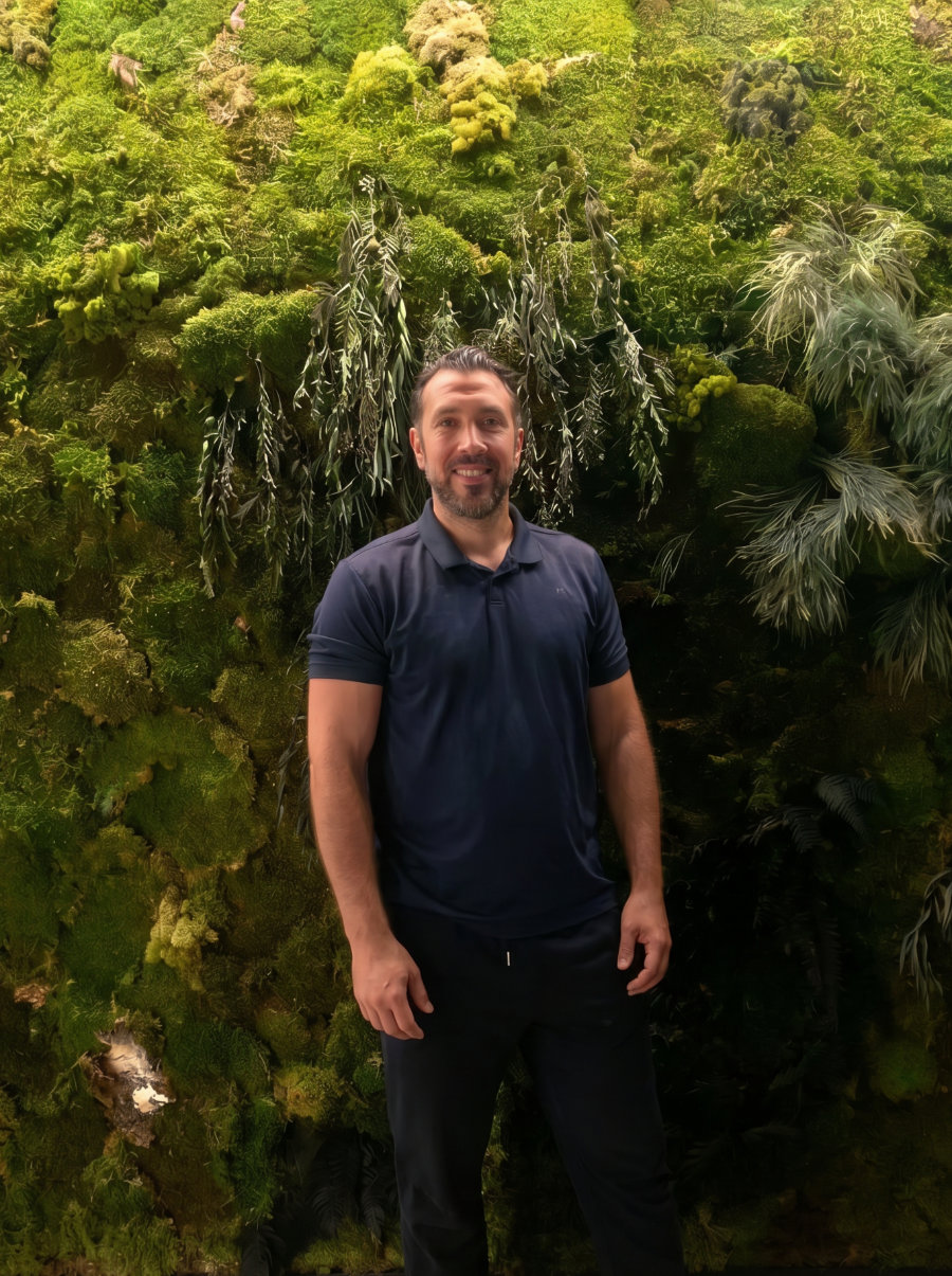 Jorge Ferrer Melero, osteópata, retratado frente a un jardín vertical